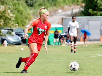 A Girl Playing Football On A Field