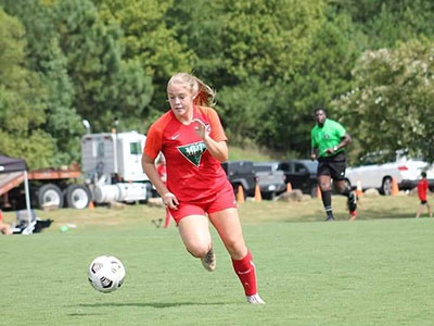 A Girl Playing Football On A Field