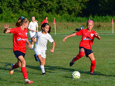 A Group Of People Playing Football On A Field